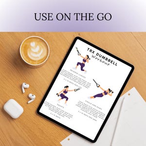 May include: A digital tablet displays a TRX dumbbell workout routine with illustrations and text. The tablet is on a wooden surface, accompanied by a cup of coffee, wireless earbuds, and a charging case. The text "USE ON THE GO" is at the top.