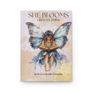 Könnte beinhalten: Ein Hardcover-Journal mit dem Titel "She Blooms: A Reflection Journal". Das Cover zeigt eine Fee mit Schmetterlingsflügeln, die ein Buch liest. Die Fee trägt ein blaues Kleid und einen Blumenkranz. Der Hintergrund ist hellgoldfarben mit dem Text "She blooms in the light of knowledge."