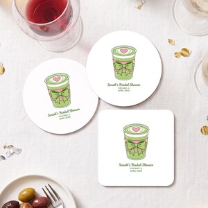 May include: Two round and one square white coasters featuring a green matcha latte illustration with a pink heart and a green bow. The text reads Sarah's Bridal Shower, Chicago, IL, April 2025. The design is centred on each coaster.