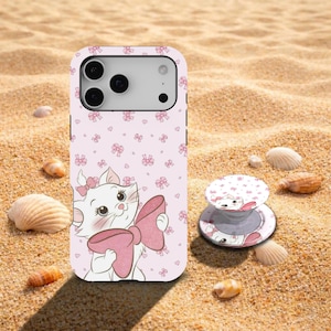 May include: A light pink smartphone case and a matching circular phone grip featuring a white cartoon cat character with a large pink bow. The background of both items is decorated with a repeating pattern of small pink bows and hearts.