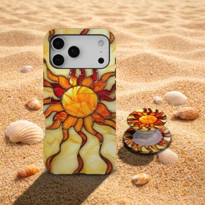 May include: A smartphone case and a matching circular collapsible phone grip featuring a stained glass sun design with yellow, orange, and red segments. The sun has a central circular core with radiating wavy rays against a light yellow background.
