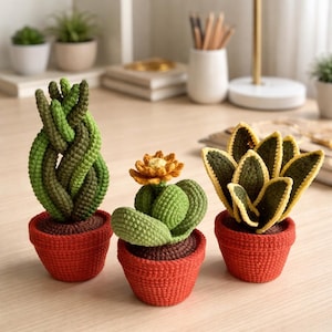 May include: Three crocheted succulent plants in red pots. The plants include a green and brown braided cactus, a green cactus with an orange flower, and a green and yellow snake plant. The pots are a vibrant red.