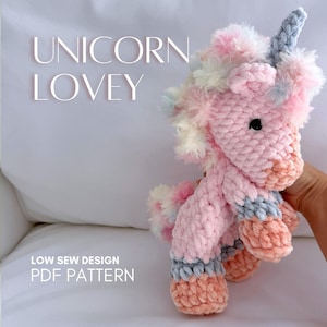 May include: A soft, pink unicorn lovey with a fluffy mane and tail, featuring pastel accents. The unicorn has a grey horn and black eyes. The text "UNICORN LOVEY" and "LOW SEW DESIGN PDF PATTERN" are visible.