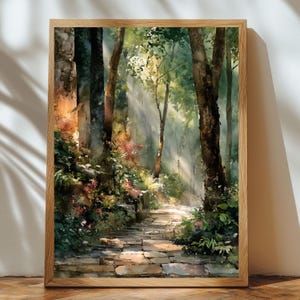 May include: Watercolor painting of a sunlit forest path. The artwork features a stone pathway winding through a lush forest with tall trees and vibrant greenery. The painting is framed in a natural wood frame.