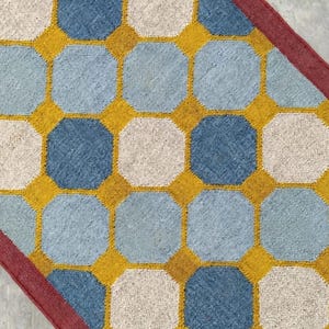 May include: A rectangular rug featuring a repeating geometric pattern of octagonal shapes in alternating shades of light blue and off-white, separated by a mustard yellow grid. The rug is finished with a solid dark red border along the edges.