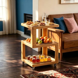 May include: A three-tiered bamboo rolling cart with swivel casters. The top shelf holds small plates of snacks and a glass carafe. The middle shelf features a tray of assorted fresh fruits. The bottom shelf contains a tray of small glass jars.