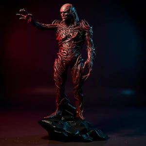 May include: A detailed, reddish-brown statue of a humanoid creature with a textured, vein-like appearance. The figure stands on a dark, rocky base, with one arm outstretched. The background features red and blue lighting.