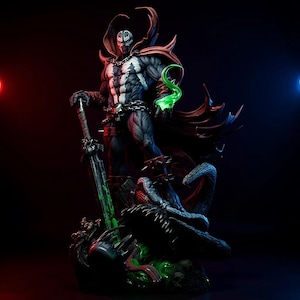 Könnte beinhalten: Detaillierte Statue der Comicfigur Spawn. Die Figur ist überwiegend schwarz und weiß mit roten Akzenten, hält ein Schwert und einen grünen Energieeffekt. Die Statue steht auf einem detaillierten Sockel mit dunklem Hintergrund.