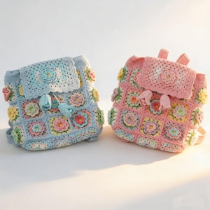 May include: Two handmade crochet backpacks, one in light blue and one in soft pink. Each bag is constructed from square floral motifs in pastel shades of yellow, green, and lavender, featuring a flap closure with a central flower and tassels.