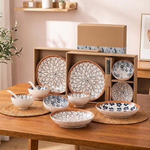 May include: A complete dinnerware set featuring plates, bowls, and spoons with a floral design. The set includes a variety of sizes, with a large plate diameter of approximately 25 cm. The color palette includes white, brown, and blue accents, perfect for a dining table.