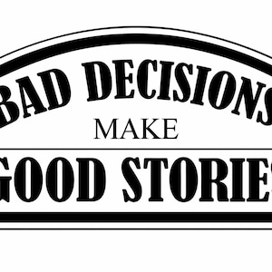 May include: A black and white sign with the text "BAD DECISIONS MAKE GOOD STORIES" in bold, stylized font. The text is arranged in three lines within a rectangular frame with rounded top corners.