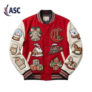Op de afbeelding: Een rood varsity-jack met crèmekleurige mouwen, voorzien van diverse geborduurde kerstpatches zoals een sneeuwbol, bel, trein, hobbelpaard, ijsbeer, wanten, bouwblokken en kerstballen, afgewerkt met gestreepte boorden bij de mouwen en zoom.