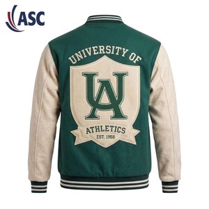 May include: A dark green varsity jacket with cream-colored sleeves, featuring a large cream shield patch on the back with the dark green text "UNIVERSITY OF UA ATHLETICS EST. 1968". The jacket has a ribbed collar, cuffs, and hem with dark green and white stripes.