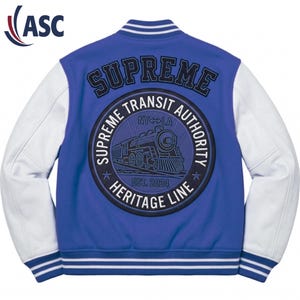 Puede incluir: Una chaqueta universitaria azul con mangas blancas y ribetes a rayas. La parte posterior presenta un gran parche circular con un gráfico de locomotora de vapor, el texto Supreme Transit Authority, Heritage Line, NY-LA y Est. 2024, con Supreme arqueado arriba.