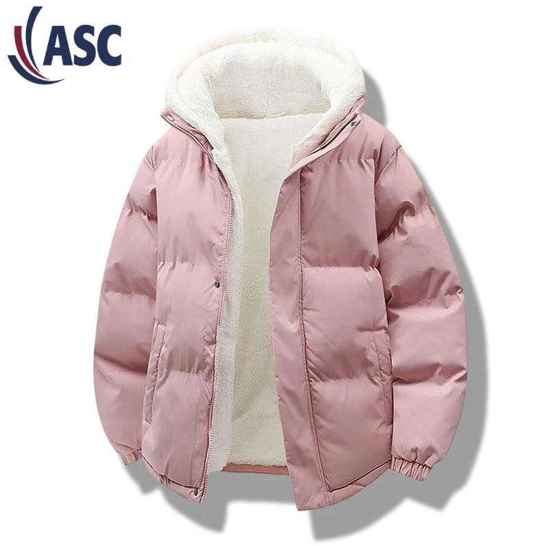 May include: A light pink puffer jacket with a hood and a white, fluffy interior. The jacket has a zipper closure and a button at the top. The logo "ASC" is visible in the upper left corner. This winter coat is designed for warmth and comfort.