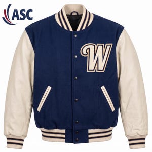 Op de afbeelding: Een marineblauw varsity-jack met crèmekleurige mouwen, voorzien van een grote crèmekleurige letter W met een donkere omlijning op de linkerborst. Het jack heeft een sluiting met drukknopen en geribbelde boorden bij de kraag, mouwen en zoom.