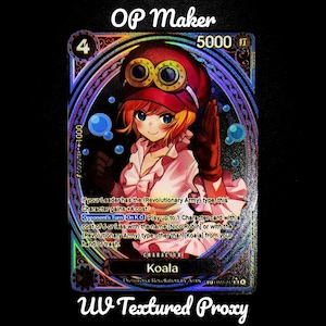 May include: A holographic trading card featuring Koala from the Revolutionary Army. The card has a colourful design with the text "OP Maker" and "UV Textured Proxy". The character Koala is depicted with red hair and a red hat.