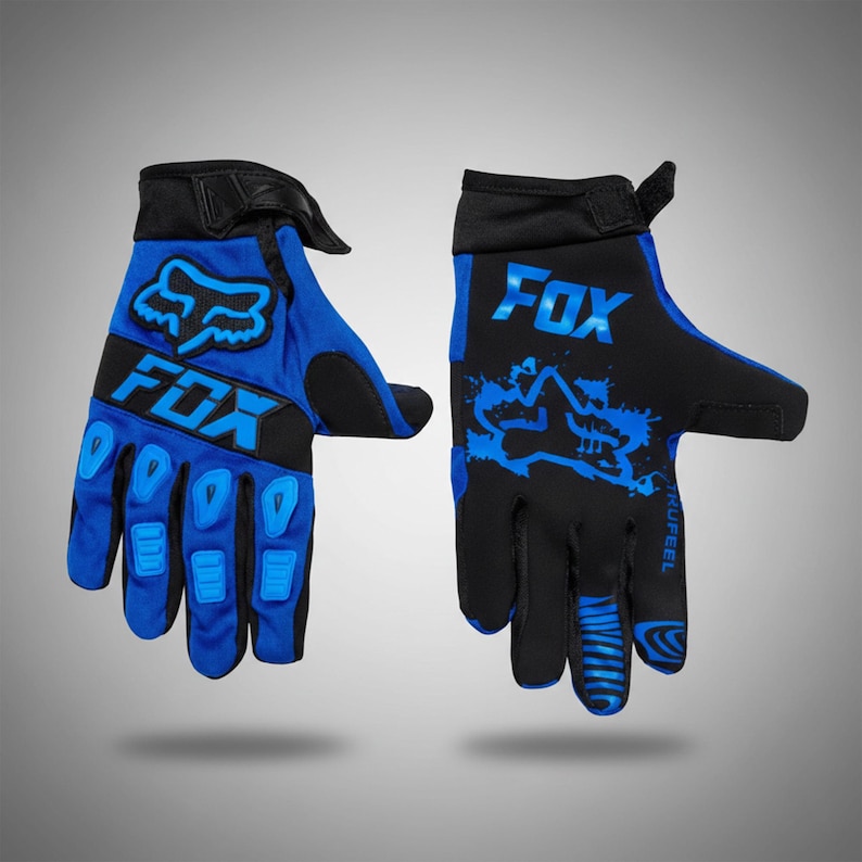 Puede incluir: Un par de guantes de carreras Fox azules y negros. Los guantes tienen un dise&ntilde;o azul y negro con el logotipo de Fox. Estos guantes est&aacute;n dise&ntilde;ados para motocross u otros deportes de acci&oacute;n.