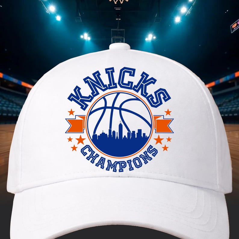 Pu&ograve; includere: Cappellino da baseball bianco con la scritta "Knicks Champions" in blu, un pallone da basket e un design di skyline. Il cappellino ha nastri arancioni e stelle, per gli appassionati di sport.