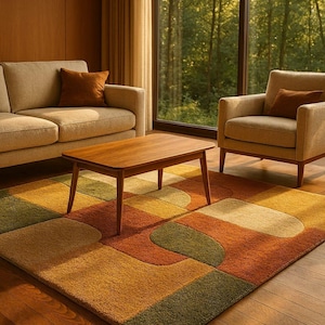 Könnte beinhalten: Ein rechteckiger Teppich mit einem geometrischen Muster aus ineinandergreifenden Formen in den Farben Olivgrün, gebranntes Orange, Senfgelb und Creme. Der Teppich hat eine strukturierte Floroberfläche und liegt auf einem Holzboden in einem Wohnzimmer.
