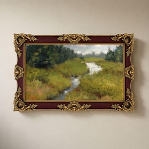 May include: A landscape painting of a winding stream through a grassy meadow with dark green trees under a cloudy sky, enclosed in a rectangular, deep burgundy frame featuring ornate, gold-colored decorative corner and edge accents.