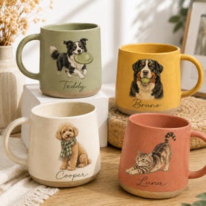 May include: Four ceramic mugs in sage green, yellow, cream, and coral. Each mug features a pet illustration and a name: Teddy with a dog, Bruno with a dog, Cooper with a dog wearing a scarf, and Luna with a cat. The mugs have a smooth finish.