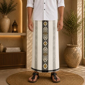 May include: A white sarong featuring a central vertical panel with dark gray and gold geometric patterns, flanked by thinner gray striped borders. The garment is worn with a white button-down shirt and black sandals, creating a clean look.