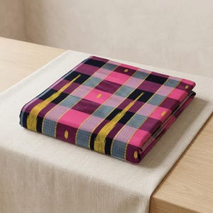 May include: A folded textile featuring a vibrant plaid pattern in shades of hot pink, deep purple, black, and muted blue. The fabric includes vertical yellow ikat-style streaks and small yellow dot accents distributed across the checkered surface.