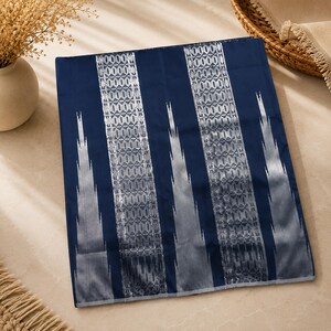 May include: A rectangular fabric piece in deep navy blue featuring two prominent vertical bands with a silver-toned geometric pattern. The design includes sharp, jagged silver accents that extend outwards from the central vertical stripes.