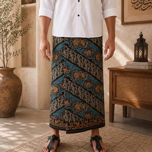 May include: A white long-sleeved button-down shirt paired with a sarong featuring a dark blue, black, and gold patterned batik design. The sarong has a wrap-around style with diagonal bands of intricate floral and geometric motifs.