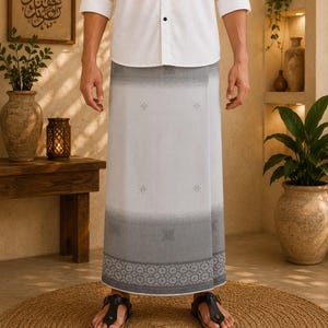 May include: A white button-down shirt paired with a light gray sarong featuring a dark gray gradient hem, subtle geometric patterns, and a decorative border. The garment is worn with black thong sandals, creating a clean and traditional look.