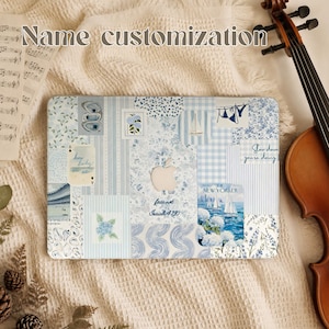May include: A laptop skin featuring a blue and white collage of various illustrations including sailboats, flowers, stripes, and text. The design includes the text "how lucky are we", "fear not", "Isaiah 41:10", "Slow down you're doing", and "NEW YORKER".