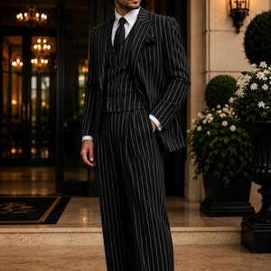 May include: A black three-piece suit with white pinstripes, featuring a blazer, a buttoned vest, and wide-leg trousers. The suit is worn with a crisp white collared shirt, a black necktie, and black and white leather dress shoes.