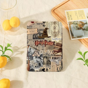 May include: A rectangular tablet case featuring a collage of Harry Potter themed imagery, including a sorting hat, the Deathly Hallows symbol, a broomstick, an owl, and stacks of books, all set against a background of vintage newspaper print.