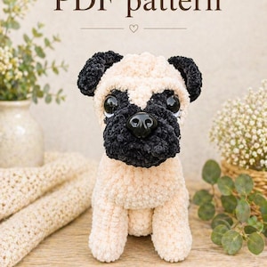 Może przedstawiać: Pluszowy, beżowo-czarny mops z dużymi, okrągłymi oczami. Pies siedzi na drewnianej powierzchni. Tekst "PDF pattern" znajduje się nad psem. Mops ma czarne uszy, czarny nos i czarną twarz.