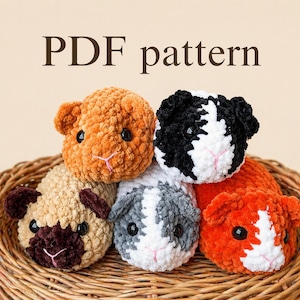 Pode incluir: Cinco peluches de porquinhos-da-índia feitos à mão em croché numa cesta de vime. Os peluches são de várias cores: laranja, preto e branco, bege com castanho, cinzento e branco e vermelho-alaranjado. O texto "PDF pattern" está no topo.