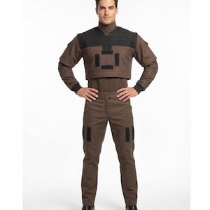 May include: A brown and black costume consisting of a turtleneck shirt, cropped vest, and pants. The vest has black rectangular patches. The pants have black patches on the thighs. The costume is worn with black boots.