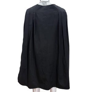 K&ouml;nnte beinhalten: Eine wei&szlig;e Keramik-Tasse mit schwarzem Henkel und dem Text "But First, Coffee" in schwarzer, handschriftlicher Schrift. Die Tasse steht auf einer wei&szlig;en Oberfl&auml;che.