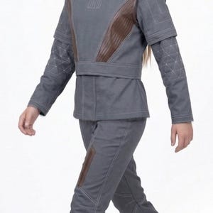 May include: A set of three ceramic nesting bowls in graduating sizes. The bowls feature a speckled, off-white glaze with a slightly textured surface. Each bowl has a rounded shape and a simple, minimalist design.