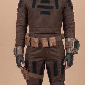May include: Brown futuristic costume with a high collar, long sleeves, and matching pants. The outfit includes a utility belt with pouches, wrist-mounted devices, and black accents. The costume appears to be made of a durable material.