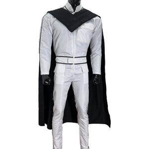 K&ouml;nnte beinhalten: Ein wei&szlig;es Kost&uuml;m mit schwarzem Umhang, Kragen und Besatz. Das Outfit umfasst eine lang&auml;rmlige Jacke, eine Hose und einen G&uuml;rtel. Die Schaufensterpuppe steht auf einem schwarzen Sockel. Das Kost&uuml;m ist wahrscheinlich f&uuml;r Cosplay oder eine Themenveranstaltung.