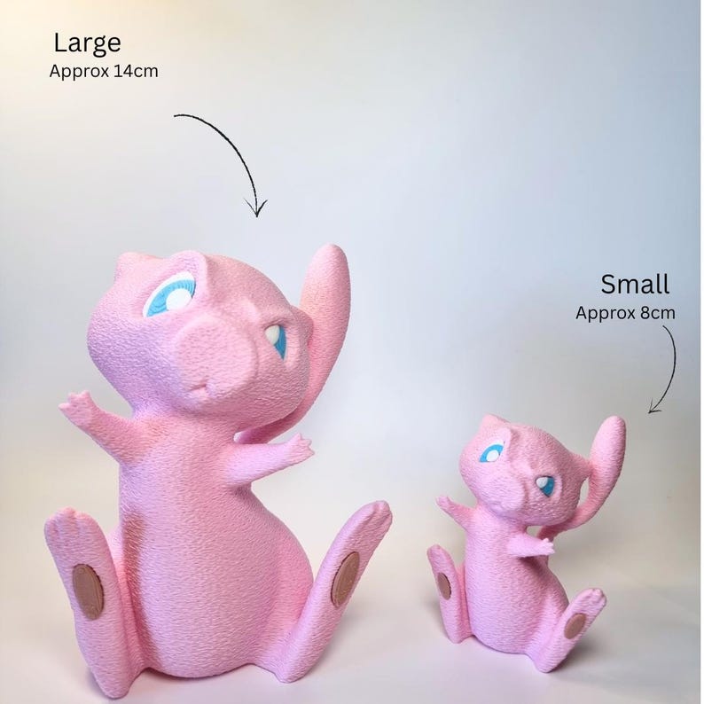 May include: Two pink textured figurines of a cat-like creature with blue eyes. The large figurine is labeled 'Large Approx 14cm' and the small figurine is labeled 'Small Approx 8cm'. Both figures are in a seated position with tails curved upward.