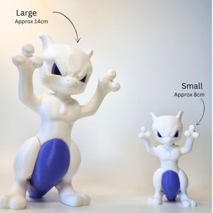 May include: Two white and purple Mewtwo figurines with pointed ears and raised arms. The large figurine is labeled as approximately 5.51 inches, while the small figurine is labeled as approximately 3.15 inches. Both figures feature a smooth finish.