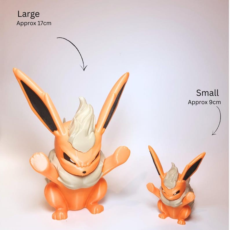 May include: Two orange and cream-colored figures with long ears and pointed features. The larger figure is labeled Large Approx 17cm, and the smaller figure is labeled Small Approx 9cm. Both figures have black accents on the ears and a cream-colored chest.