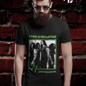 Może przedstawiać: Czarny t-shirt z nazwą zespołu Type O Negative i wizerunkiem członków zespołu. Zielono-biała grafika zawiera również frazę "Life Is Killing Me". Całość jest oprawiona.