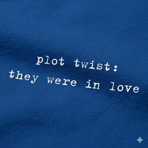 Puede incluir: Primer plano de una tela azul real con el texto blanco "plot twist: they were in love". El texto está en una fuente sencilla, sin serifa. La tela tiene una textura sutil.
