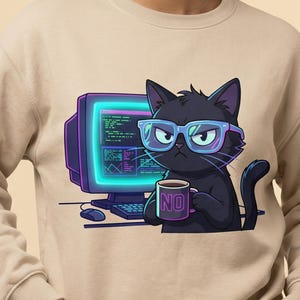 Könnte beinhalten: Beiges Sweatshirt mit einer Cartoon-Katze mit Brille, die eine Tasse mit dem Wort "NO" hält. Die Katze steht vor einem Retro-Computermonitor mit Tastatur und Maus.