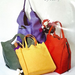 May include: A collection of handmade tote bags in various colors, including purple, green, yellow, and red. The bags have unique scalloped edges and handle designs. The image includes the text "by Mary Mulari".