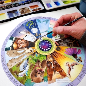 May include: A watercolor painting of a circular calendar with zodiac symbols, animals, and phases of the moon. The artist's hand holds a paintbrush, adding details to the artwork. The painting includes text such as "Stillness" and "Radiance."
