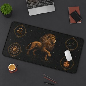 Peut inclure: Un tapis de bureau rectangulaire présentant une illustration centrale de lion doré sur fond noir. Le design comprend quatre emblèmes circulaires représentant le symbole du zodiaque Lion, un soleil, la constellation du Lion et des flammes, en or.